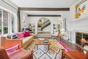 The sunken living room has a wood beamed ceiling and a fireplace.